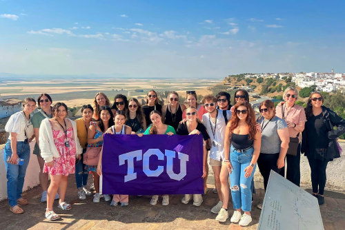 Students traveling abroad holding TCU flag