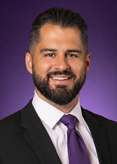 Headshot of Austin Graybeal with a TCU purple background. Austin is wearing a white, buttoned collared shirt with a black jacket and purple tie.