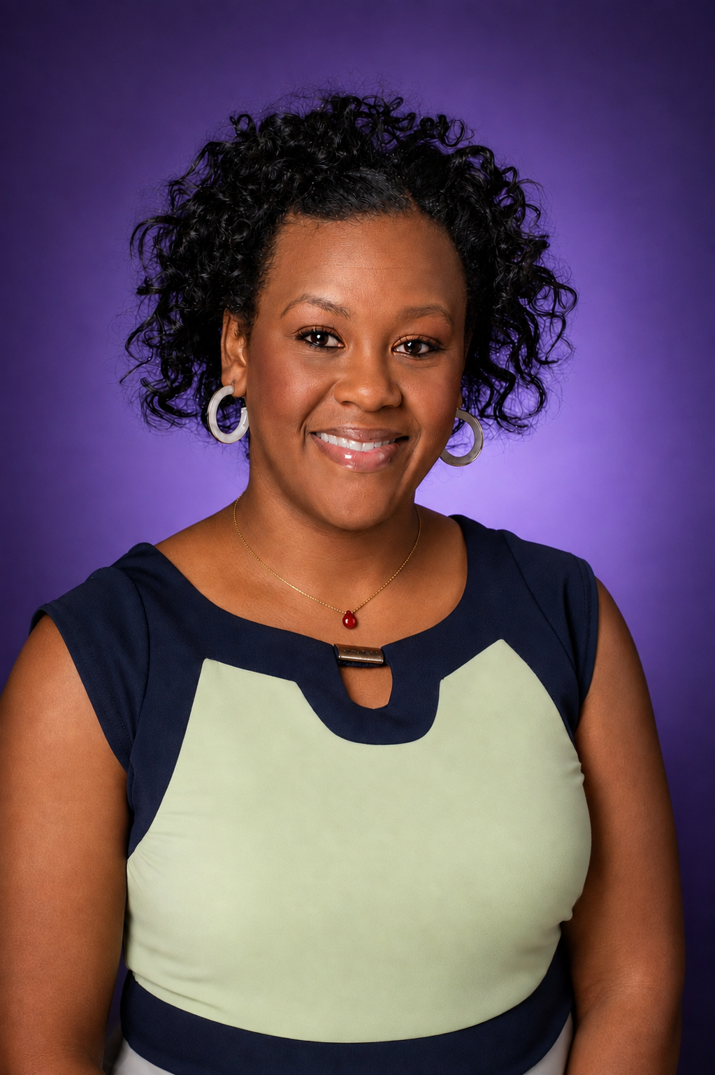 A woman smiling, wearing a light green and black dress with a purple background.
