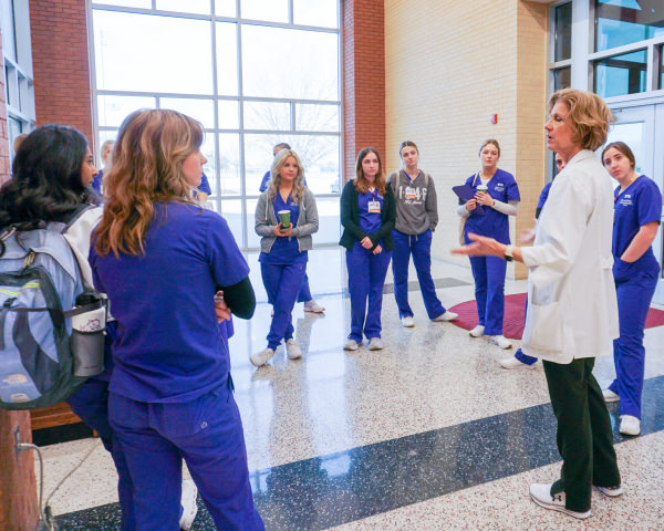 Professor talks to a group of nursing students