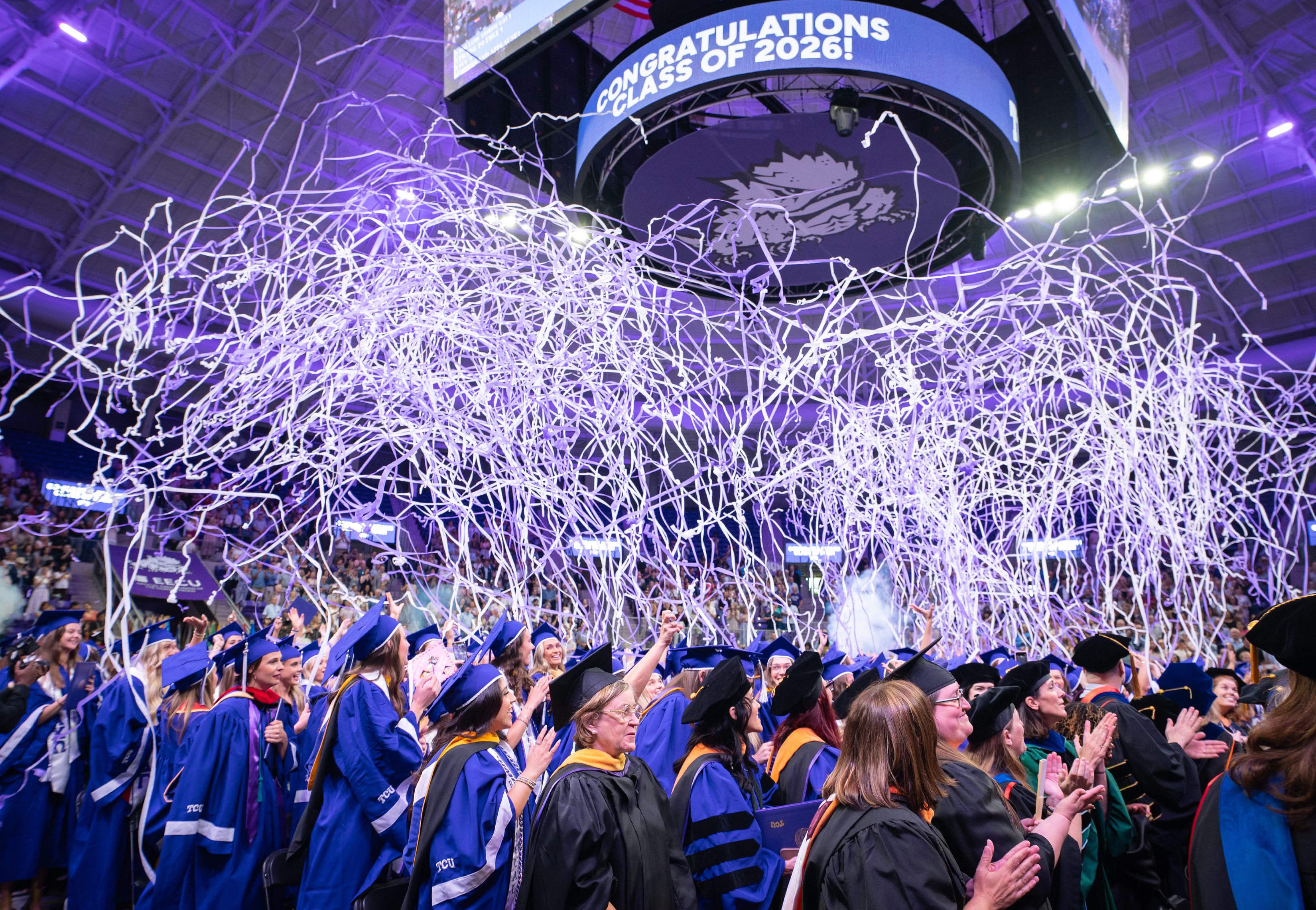 Purple and white confetti streamers falling at the May 2026 commencement ceremony for Harris College of Nursing and Health Sciences