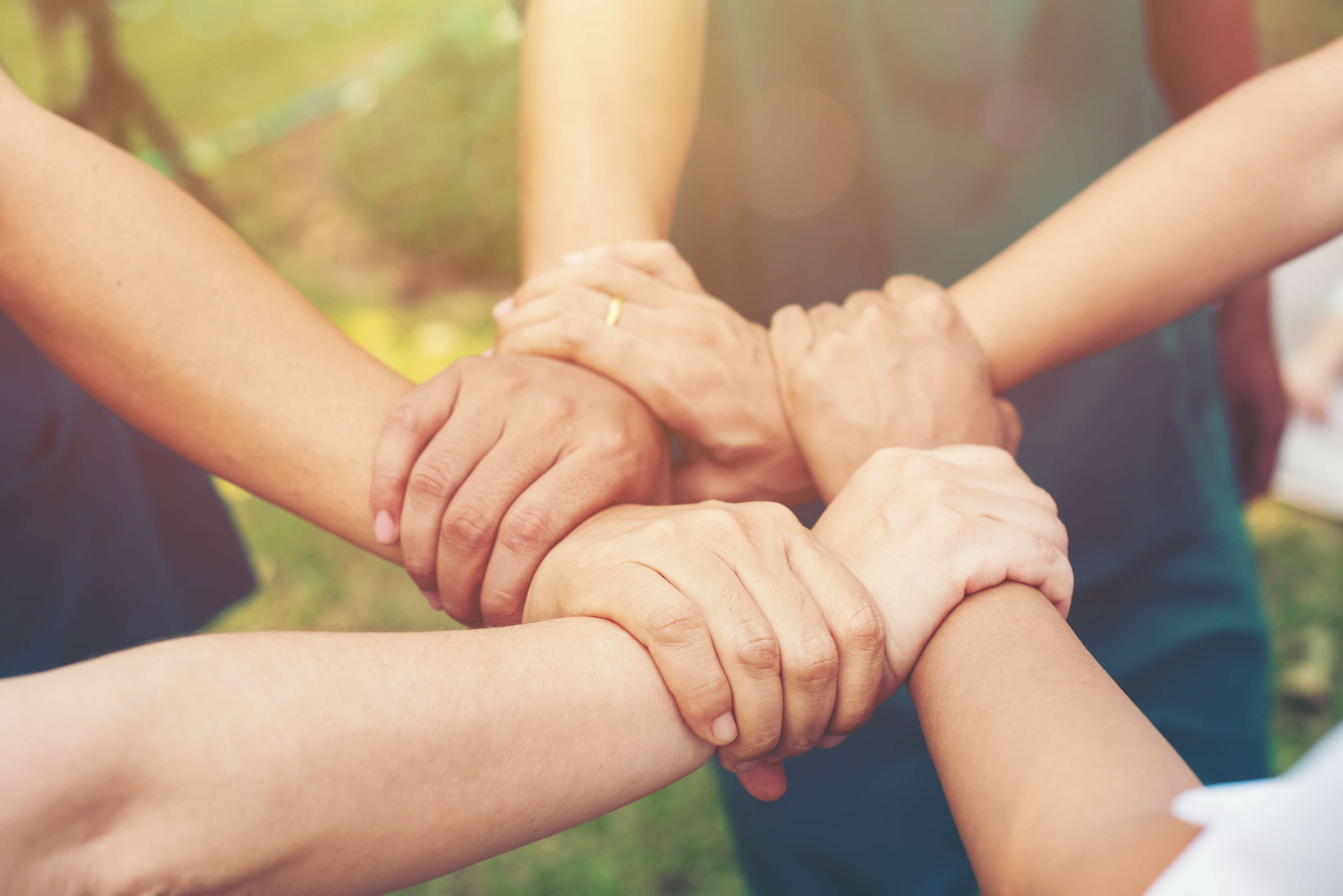 Generic photo of five people holding hands in collaboration