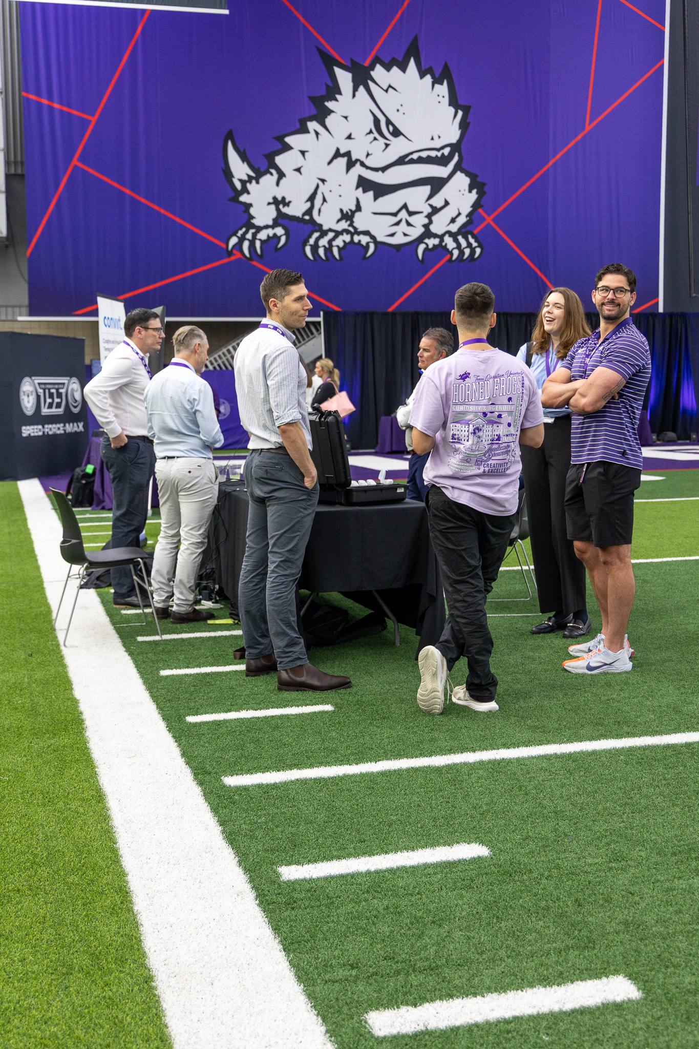 A booth from Deakin University showcasing VR technology during a horse-riding simulation at the Global Human Performance Forum. Researchers from Deakin speaking with TCU Kinesiology Ph.D. and Graduate students.