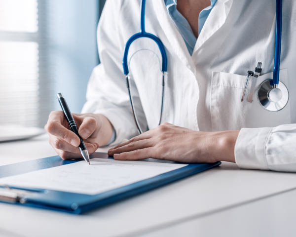 practitioner or doctor writing notes at desk