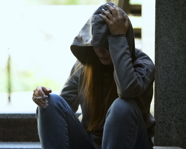A woman sitting and smoking a cigarette
