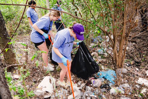 Students outside cleaning up trash