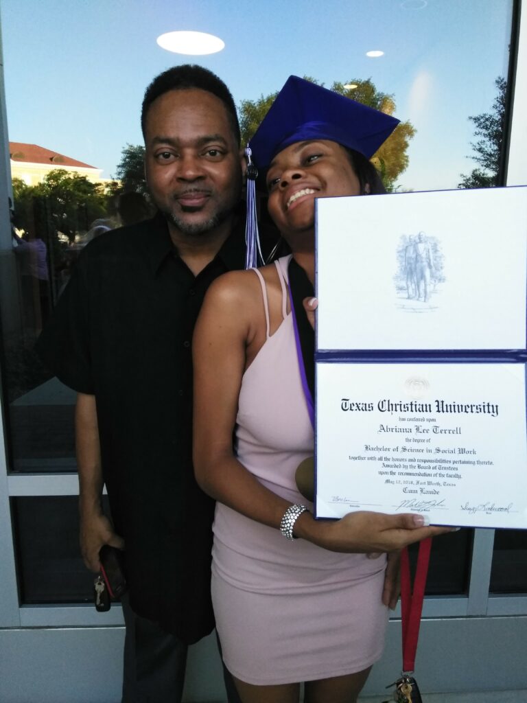 Abriana holding her TCU degree on graduation day