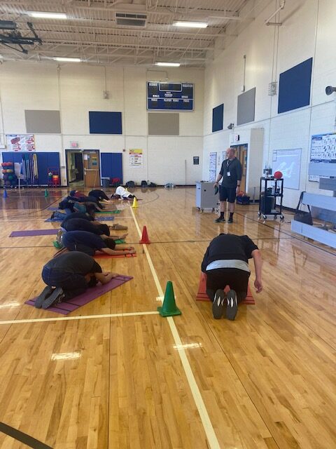 Arrow instructing his students through a yoga routine.