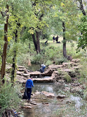 TCU students picking up trash from the water at glenwood park