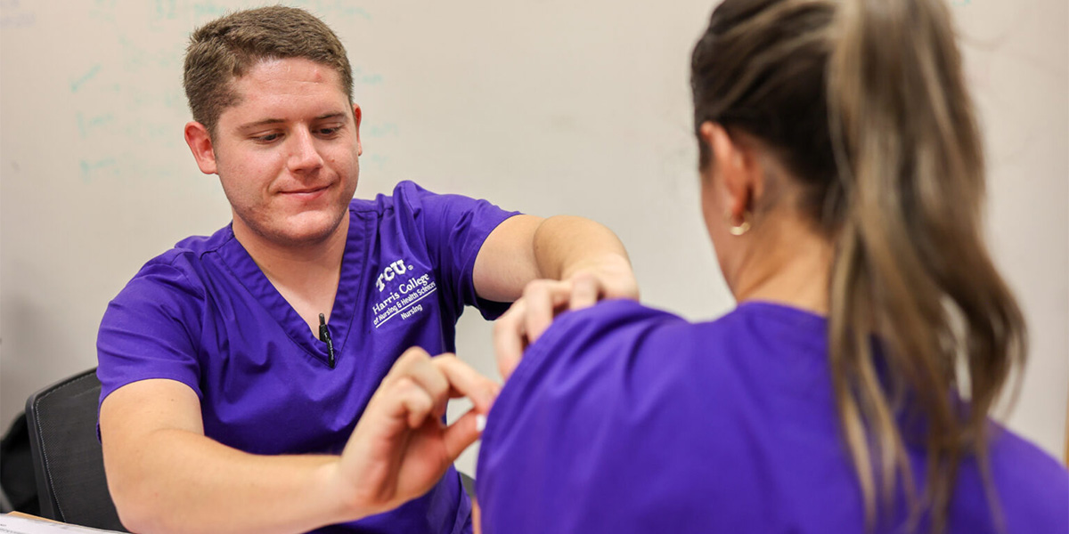 TCU Nursing senior practices administering the flu vaccine on another student in preparation for the upcoming flu clinic event.