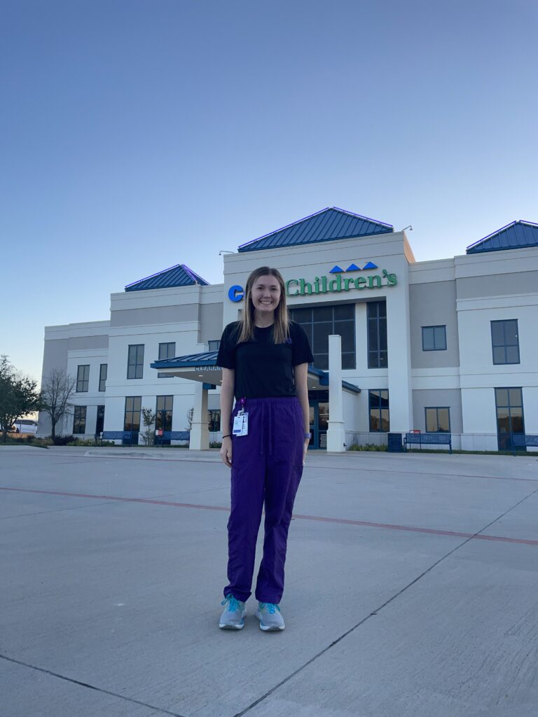Katie Smith, a first-year master’s athletic training student, poses for a photo in front of her clinical rotation site.