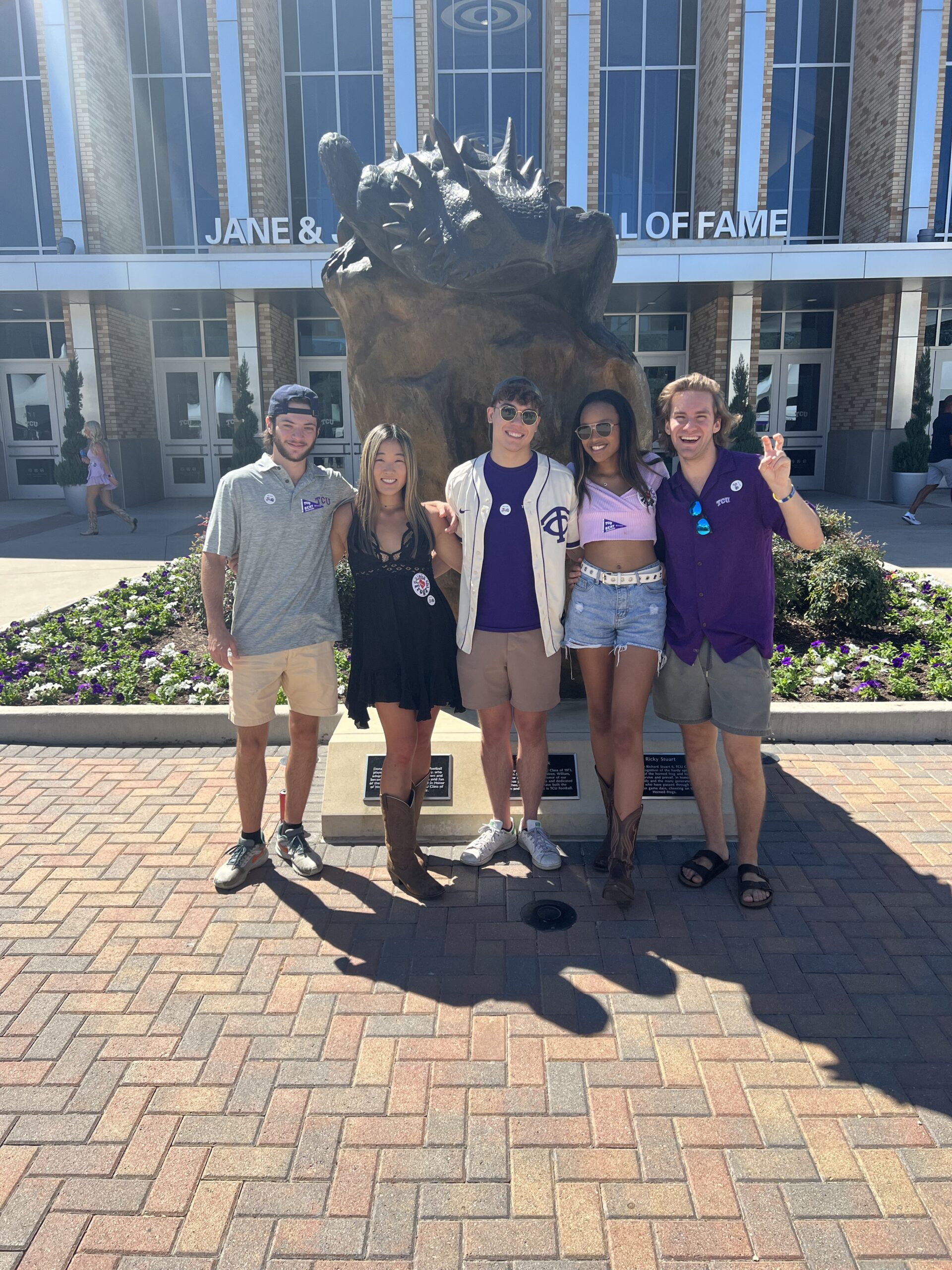 Kyndal and her friends posing in front of a horned frog statue