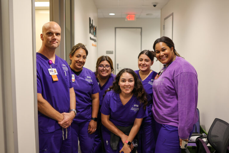 Nursing students pose for a photo as they wait in line to practice administering the flu vaccine