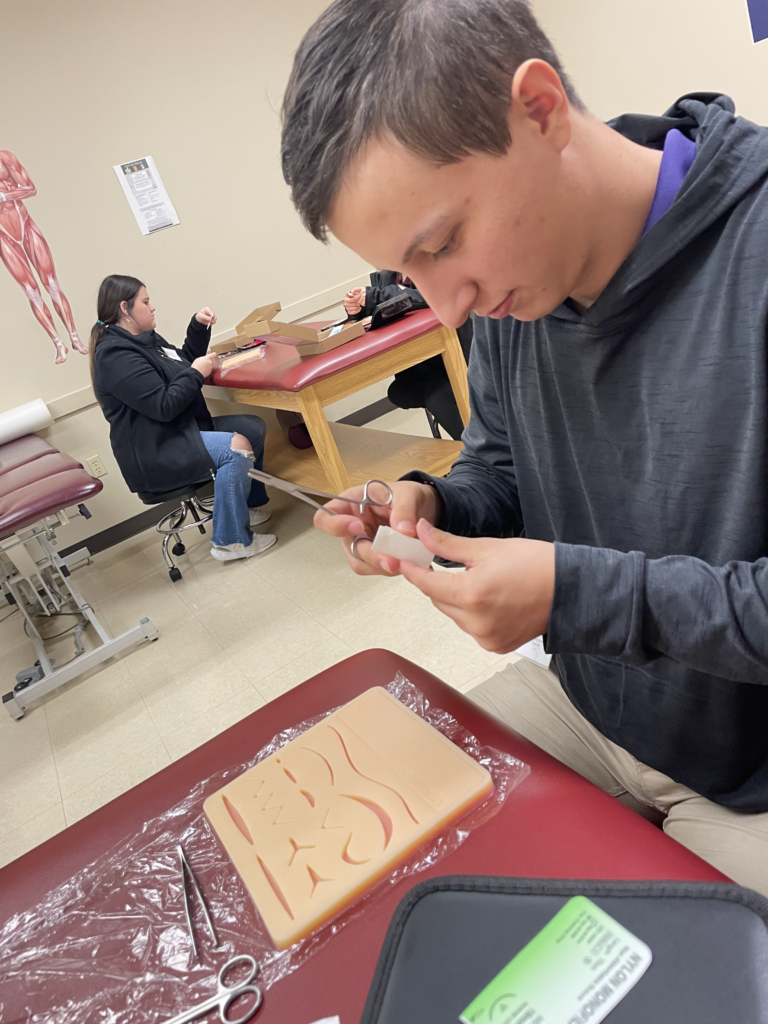 TCU athletic training student practices their suturing skills at the SWATA
