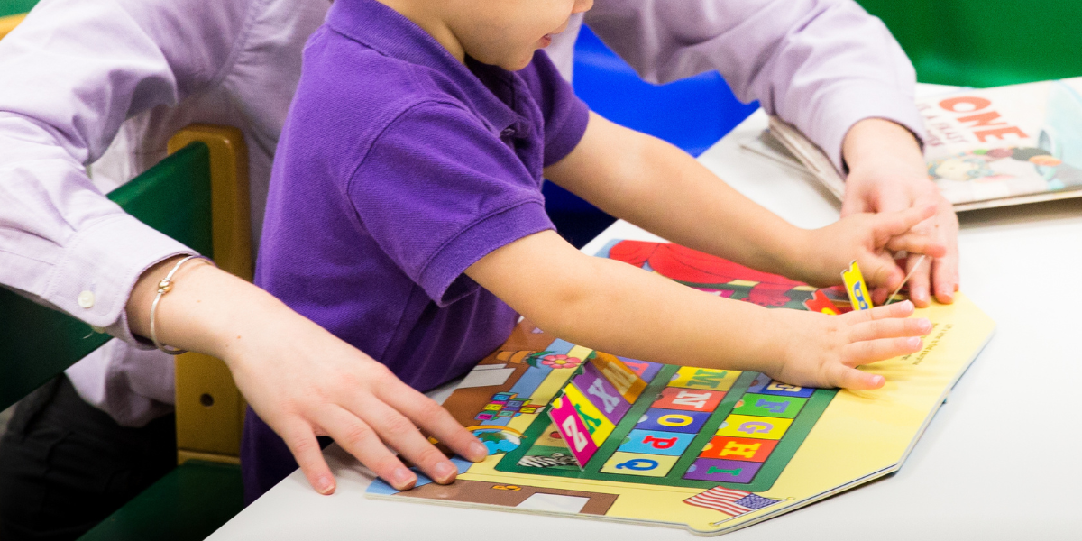 COSD student doing hands on learning with a young child at the Miller Speech & Hearing Clinic